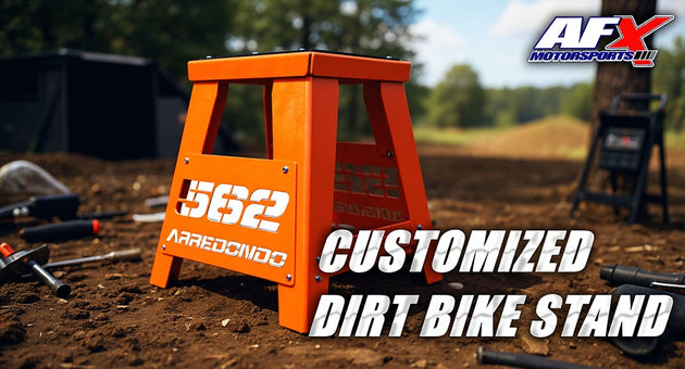 Orange dirt bike stand with '562 Arredondo' branding on a dirt track background, featuring AFX Motorsports logo.
